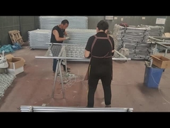 Les ouvriers utilisent du fil pour connecter la clôture et le tube de cadre.